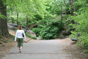 Woman walking on trail in forest